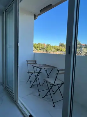 a balcony with a table and chairs looking out at the ocean at Superbe appartement avec balcon et parking in Aix-en-Provence