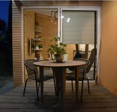 a table with chairs and a plant on a patio at Le gîte du petit branché in Mazan