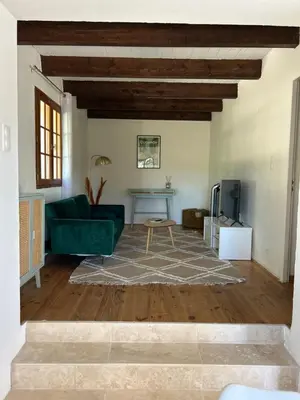 a living room with a green couch and a table at Gite Les Robiniers in Beaumont-de-Pertuis