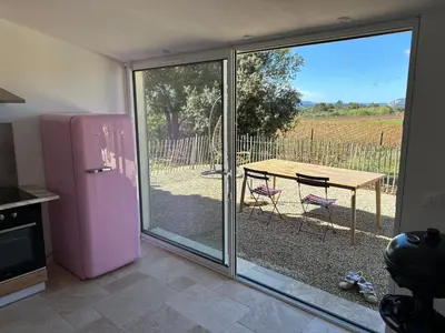 a kitchen with a pink refrigerator and a table at Gite Les Robiniers in Beaumont-de-Pertuis