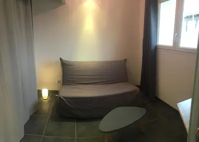 a bed in a room with a pillow and a chair at 2 pièces et mezzanine dès 2 nuits in Vedène