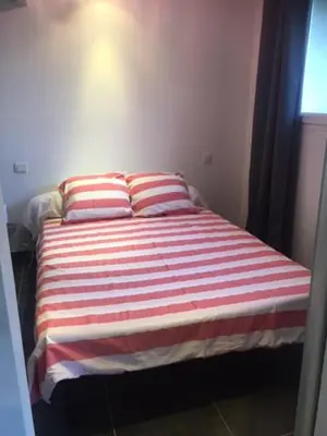 a bed in a room with two pillows on it at 2 pièces et mezzanine dès 2 nuits in Vedène