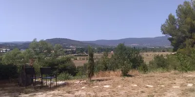 two chairs sitting on a hill in a field at Bienvenue à la Source dans une Maison de Charme in Apt