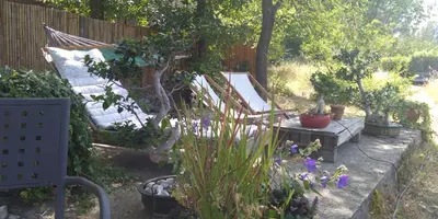 a garden with a couch and a table with flowers at Bienvenue à la Source dans une Maison de Charme in Apt