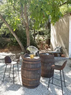 a wooden table with chairs and a bottle on top at La ferme du TourreBlanc in Lambesc