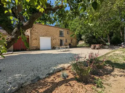 a barn with a white door and a building at La ferme du TourreBlanc in Lambesc