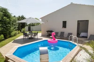 a swimming pool with a pink flamingo in a backyard at Les Villas des Fontaines in Saumane-de-Vaucluse