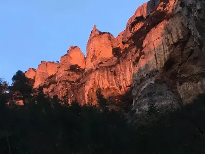 a rocky mountain with the sun shining on it at Les Villas des Fontaines in Saumane-de-Vaucluse