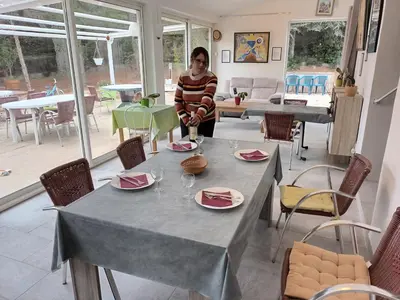 a woman standing next to a table with plates on it at Chambre raisin 2p, pour 2 nuits max, a 6km du festival de piano de la roque d'anthéron à 100m de la piscine in Rognes