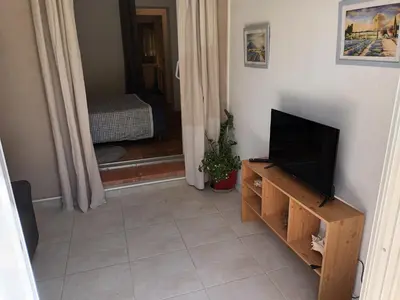 a living room with a flat screen tv on a stand at Chambre raisin 2p, pour 2 nuits max, a 6km du festival de piano de la roque d'anthéron à 100m de la piscine in Rognes