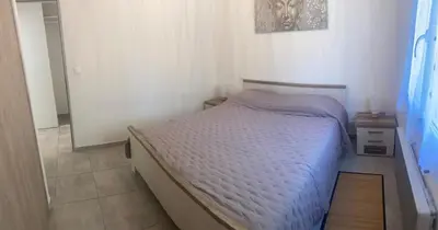 a small bedroom with a bed and two night stands at Le Ribbou in LʼIsle-sur-la-Sorgue