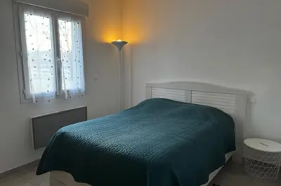 a bedroom with a bed and a lamp and a window at Le Ribbou in LʼIsle-sur-la-Sorgue