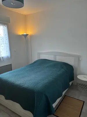 a bedroom with a bed with a green comforter at Le Ribbou in LʼIsle-sur-la-Sorgue
