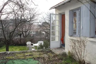 a white house with a door and a table and chairs at Maison accueillante à Reillanne avec jardin clos in Reillanne