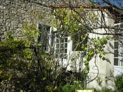 a stone building with a window and a tree at Maison accueillante à Reillanne avec jardin clos in Reillanne