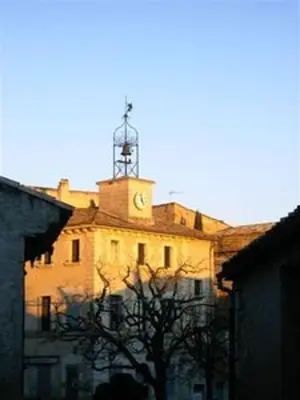 a building with a clock tower on top of it at Maison accueillante à Reillanne avec jardin clos in Reillanne