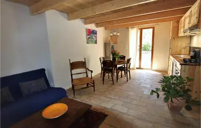 a living room with a couch and a table with chairs at 2 Bedroom Beautiful Home In St Didier in Saint-Didier