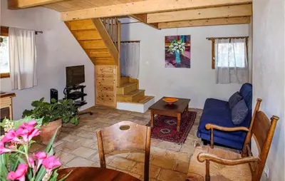 a living room with a blue couch and a tv at 2 Bedroom Beautiful Home In St Didier in Saint-Didier