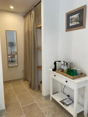 a room with a white table and a mirror at Le Mas de Caroline in Gargas
