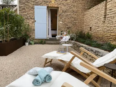 a patio with two chairs and a table at Le Mas de Caroline in Gargas