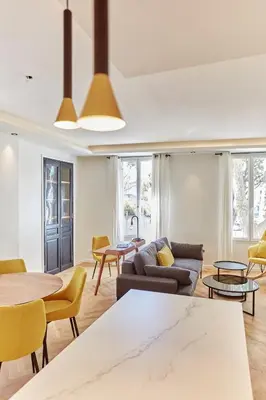 a living room with a couch and tables and chairs at Appartement exceptionnel avec parking Centre-ville Aix-en-Provence in Aix-en-Provence
