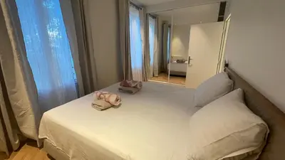 a bedroom with a large white bed with a mirror at Appartement exceptionnel avec parking Centre-ville Aix-en-Provence in Aix-en-Provence