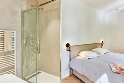 a bedroom with a glass shower and a bed at Appartement exceptionnel avec parking Centre-ville Aix-en-Provence in Aix-en-Provence