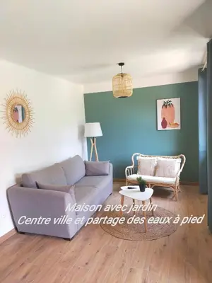a living room with a couch and a table at Gîte Les Demoiselles des Sorgues in LʼIsle-sur-la-Sorgue