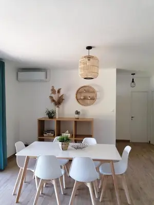 a white dining room with a white table and chairs at Gîte Les Demoiselles des Sorgues in LʼIsle-sur-la-Sorgue