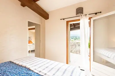 a bedroom with a bed and a balcony at Au petit bonheur in Bédoin