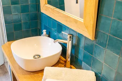 a bathroom with a white sink and a mirror at Au petit bonheur in Bédoin