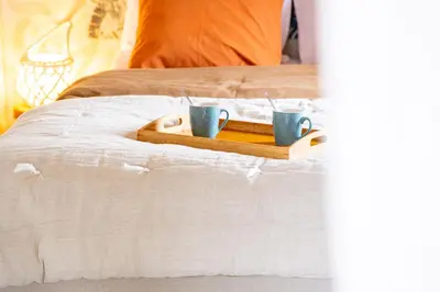 two coffee cups on a tray on a bed at Au petit bonheur in Bédoin