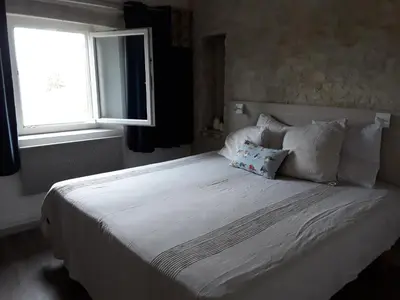 a white bed with two pillows and a window at Chambre du sentier des ocres in Roussillon