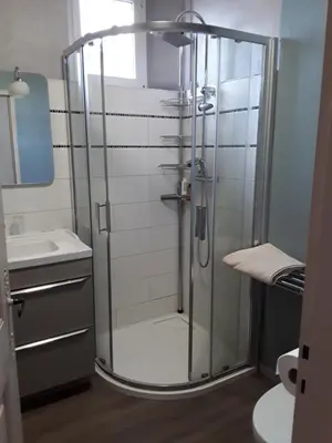 a glass shower in a bathroom with a sink at Chambre du sentier des ocres in Roussillon
