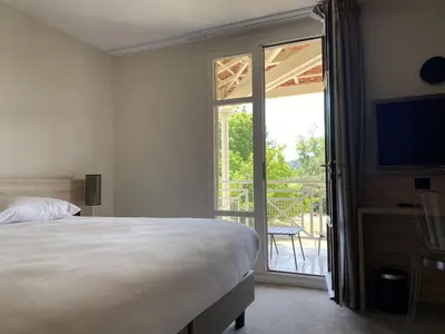 a bedroom with a bed and a sliding glass door at Domaine de la Reynaude in Aurons