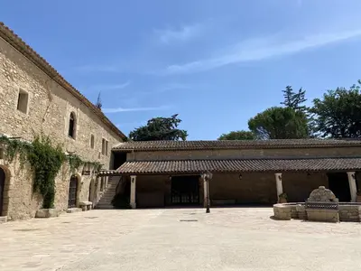 a building with trees in front of a sunset at Domaine de la Reynaude in Aurons