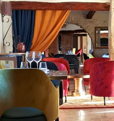a dining room with chairs and tables with wine glasses at Domaine de la Reynaude in Aurons