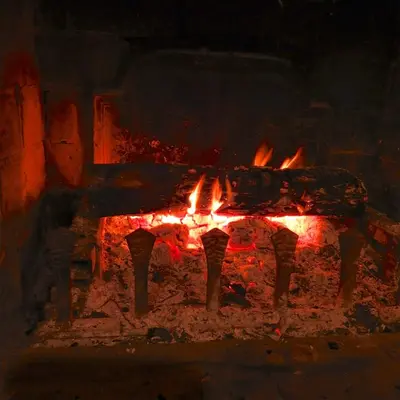 a fire in a brick oven with flames at Domaine de la Reynaude in Aurons
