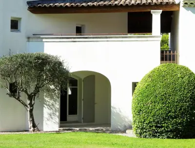 a white house with a tree in the yard at La Tour D'Orgueil in Mallemort