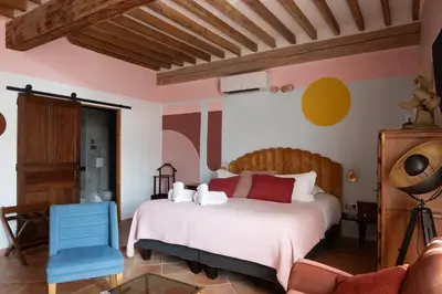 a bedroom with a white bed and a blue chair at La Maison d'en Bas des Seigneurs in Cucuron