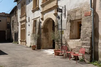 two red chairs sitting outside of a building at La Maison d'en Bas des Seigneurs in Cucuron