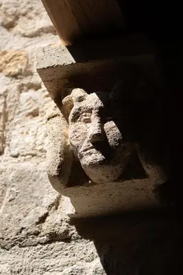 a stone statue of a face on a wall at La Maison d'en Bas des Seigneurs in Cucuron