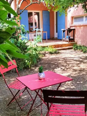 a pink table with a pineapple on it next to two chairs at Calme et Intimité proche Avignon Piscine options au choix privée ou partagée de juin à octobre in Morières-lès-Avignon