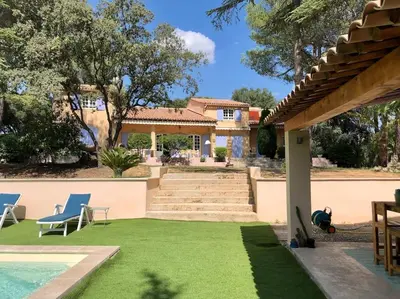 a house with a yard with a pool and grass at Villa Bois Romay dans le Luberon avec piscine, tennis et pétanque. in La Bastide-des-Jourdans