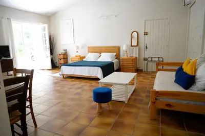 a bedroom with two beds and a table and a couch at Villa Bois Romay dans le Luberon avec piscine, tennis et pétanque. in La Bastide-des-Jourdans