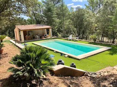a swimming pool in a yard next to a house at Villa Bois Romay dans le Luberon avec piscine, tennis et pétanque. in La Bastide-des-Jourdans
