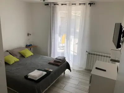a small bedroom with a bed and a window at Au milieu des Piboules de Provence. in LʼIsle-sur-la-Sorgue
