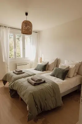 a white bedroom with two beds with towels on them at GITE LE TILLEUL in Mormoiron