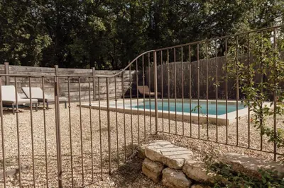 a metal fence next to a swimming pool at GITE LE TILLEUL in Mormoiron
