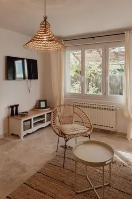 a living room with a chair and a table and a tv at GITE LE TILLEUL in Mormoiron